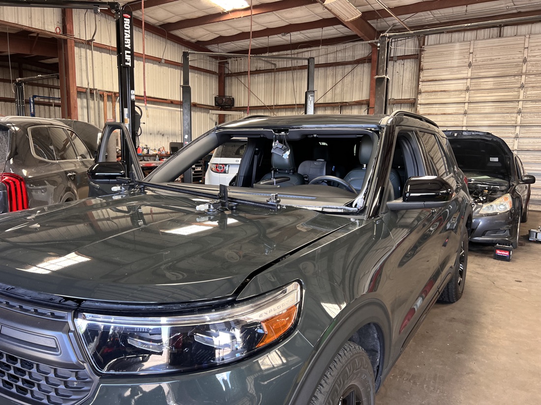 Ford Explorer windshield being set with a glass-setting bar during a replacement at the South Texas Auto Glass shop in Corpus Christi, TX
