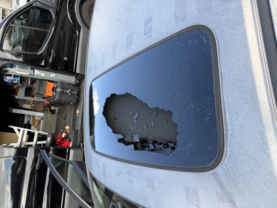 Sunroof glass removed from a vehicle with the old adhesive being cleaned off during a sunroof replacement by South Texas Auto Glass in Corpus Christi, TX