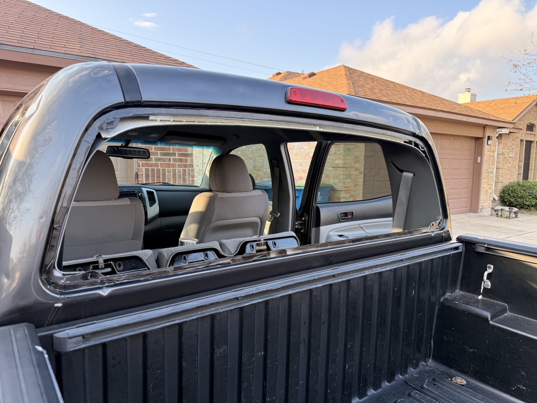 Rear back glass removed from a Toyota Tacoma pickup during a mobile back glass replacement at a customer's home in the Corpus Christi area