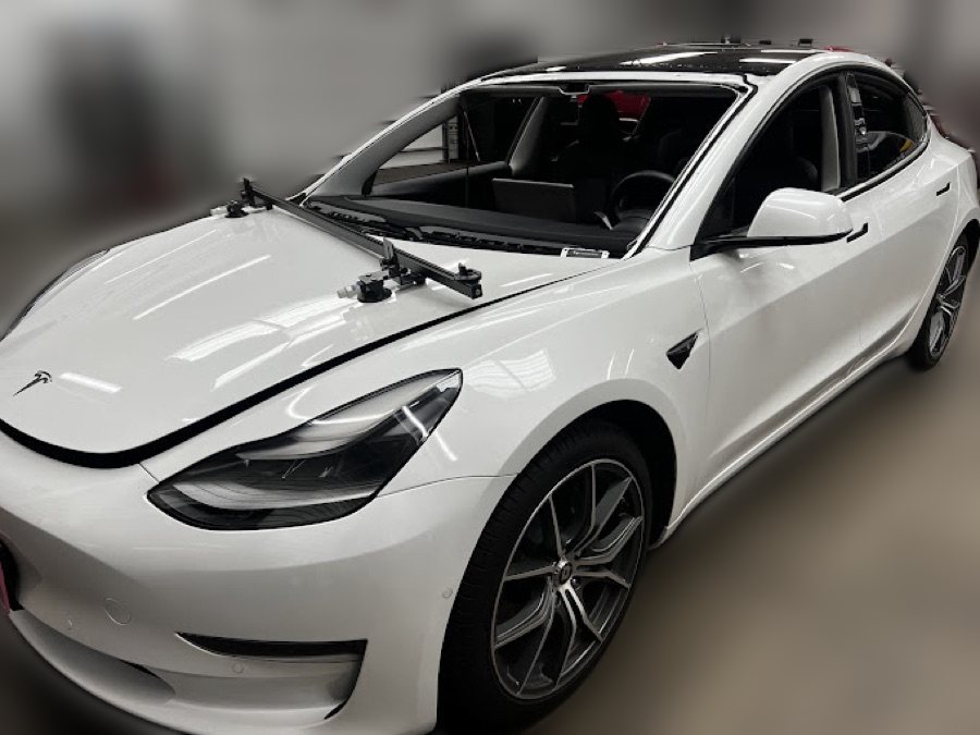 White Tesla Model 3 with a windshield-setting tool during a replacement at South Texas Auto Glass