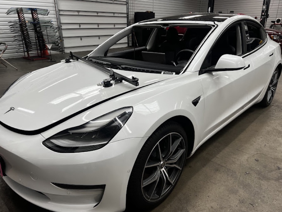 White Tesla Model 3 with a windshield-setting tool during a replacement at South Texas Auto Glass